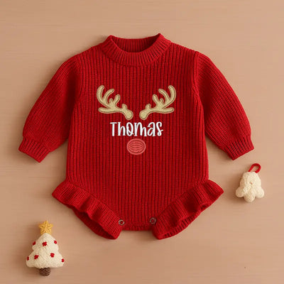 Red baby romper with reindeer antlers and 'Thomas' text on a beige background