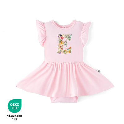 Pink baby dress with floral letter design on a white background, featuring OEKO-TEX certification.