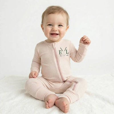 Baby golf pjs wearing a sand onesie with a zipper on a white background