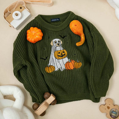 Green sweater with Halloween-themed design featuring a ghost and pumpkins on a neutral background.