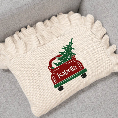Cream personalized baby blanket with a Christmas tree in the car design on a gray surface