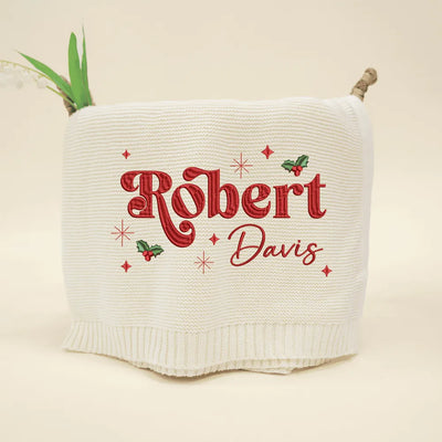 Cream personalized baby blanket with 'Robert Davis' embroidered in red on a beige background