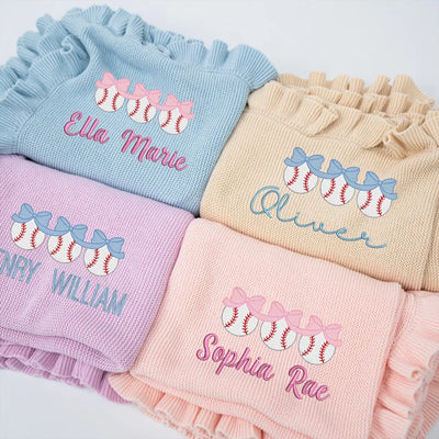 Stack of personalized baseball bow knitted baby girl blankets with names embroidered on them.