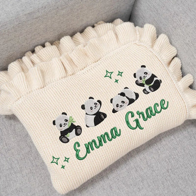 Personalized baby blanket with panda design and 'Emma Grace' text on a gray surface
