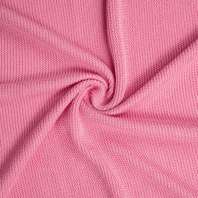 Close-up of rose pink ruffle knitted baby blanket with a subtle texture